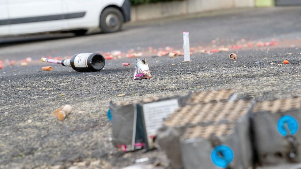 Auf einer Straße liegen abgebrannte Böller und Raketen. Foto: Pia Bayer / dpa