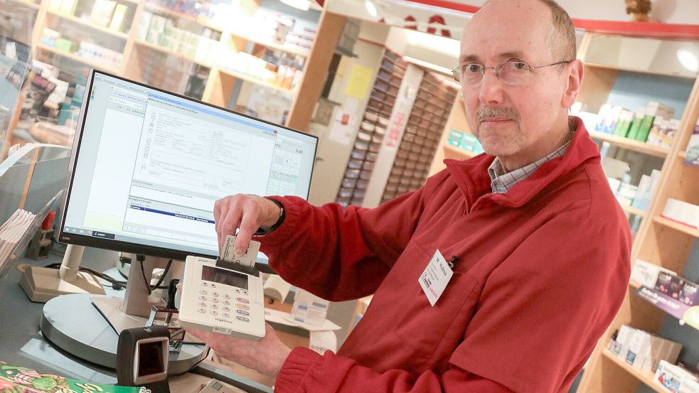 Wolfgang Waßmus von der Löwen-Apotheke in Aurich steckt eine Gesundheitskarte in ein Lesegerät, um das E-Rezept eines Patienten abrufen zu können. Foto: Romuald Banik