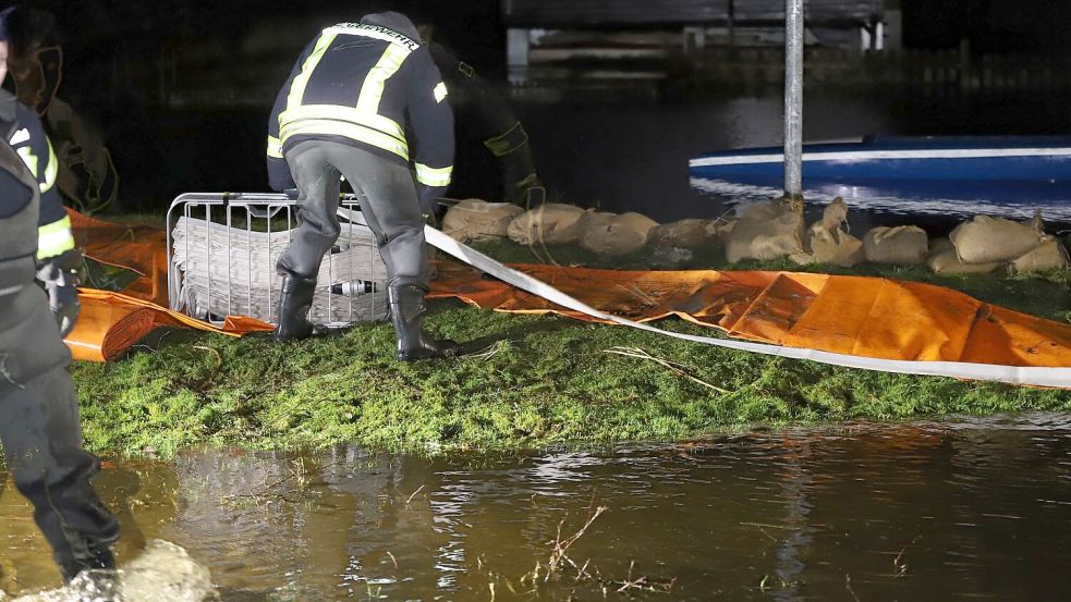 Einsatzkräfte der Südbrookmerlander Feuerwehren kämpften zusammen mit dem Entwässerungsverband, dem THW und den Bauhofmitarbeitern gegen die weitere Ausbreitung des Wassers. Dazu wurde unter anderem wieder ein Tigerdamm als Barriere erreichtet. Foto: Wilfried Gronewold