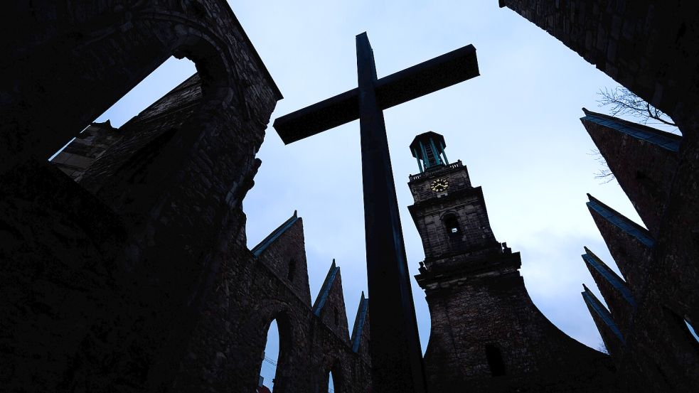 Das Kreuz einer Kirche im Abendhimmel: Auch in den Kirchenkreisen Aurich und Norden ist die Stimmung getrübt. Foto: DPA