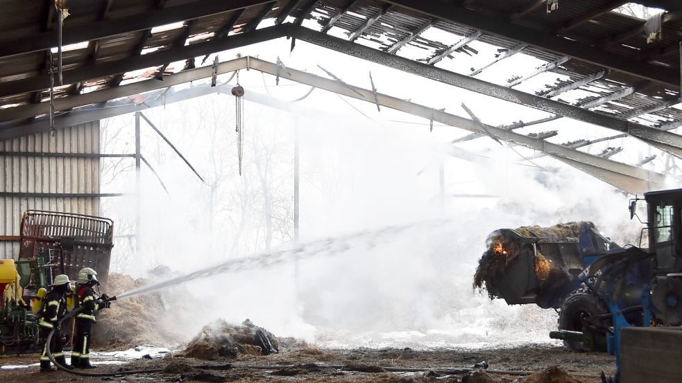Stunden nach dem abendlichen Brand war die Feuerwehr noch vor Ort, um das brennende Stroh in der zum Teil zerstörten Halle zu löschen. Foto: Thomas Dirks