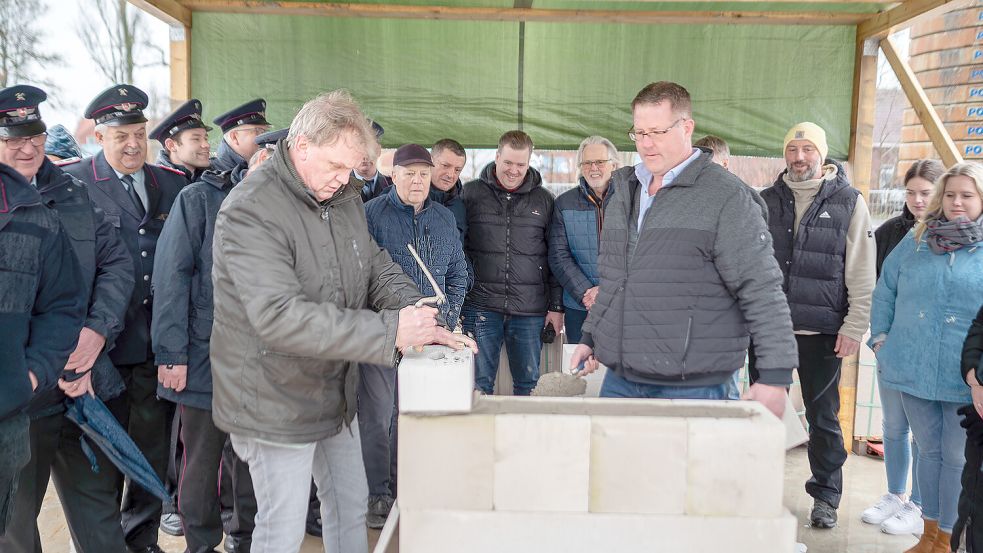 Bürgermeister Thomas Erdwiens und stellvertretender Bauamtsleiter Frank Süßen mauerten die Zeitkapsel ein. Foto: Folkert Bents