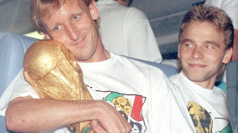 Andreas Brehme hält im Jahr 1990 den gerade eroberten WM-Pokal im Arm. Nun starb die deutsche Fußball-Ikone im Alter von 63 Jahren. Foto: dpa/Frank Kleefeldt