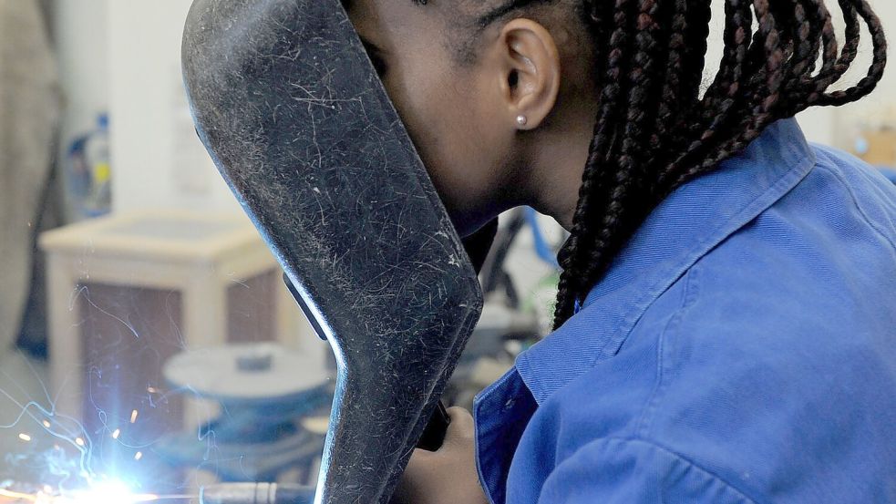 Eine Schülerin aus dem afrikanischen Guinea absolviert in der Metallwerkstatt der Allgemeinen Berufsschule in Bremen einen Kurs im E-Schweißen. Foto: Ingo Wagner/dpa