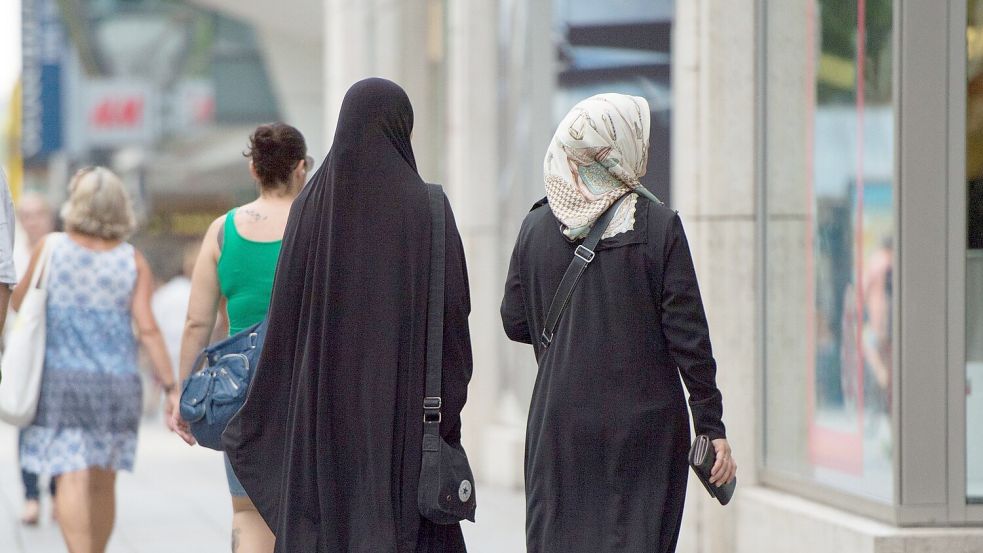 Zwei Frauen mit Kopftuch und langer Oberbekleidung. Foto: Marijan Murat/dpa