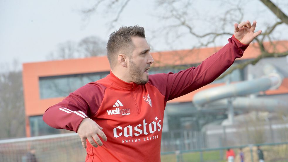 Es sieht fast so aus, als würde der Auricher Trainer Claudio Casto an der Seitenlinie Luftgitarre spielen, um seine Fußballer wie im Heimspiel gegen Larrelt mit energiegeladenen Akkorden anzutreiben. Foto: Bernd Wolfenberg