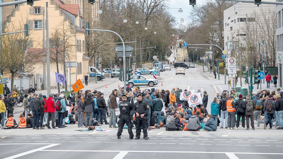Aktivistinnen und Aktivisten der Letzten Generation blockieren eine Kreuzung in Regensburg. Foto: Daniel Vogl/dpa