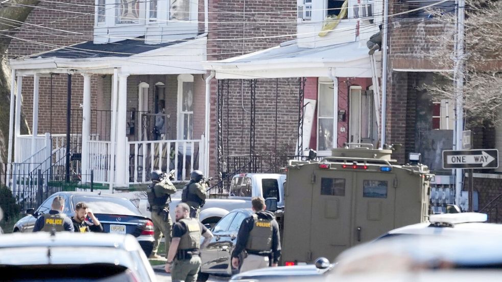Polizisten umstellen das Haus in Trenton, in dem sich der mutmaßliche Täter mit seinen Geiseln verschanzt hat. Foto: Matt Rourke/AP/dpa