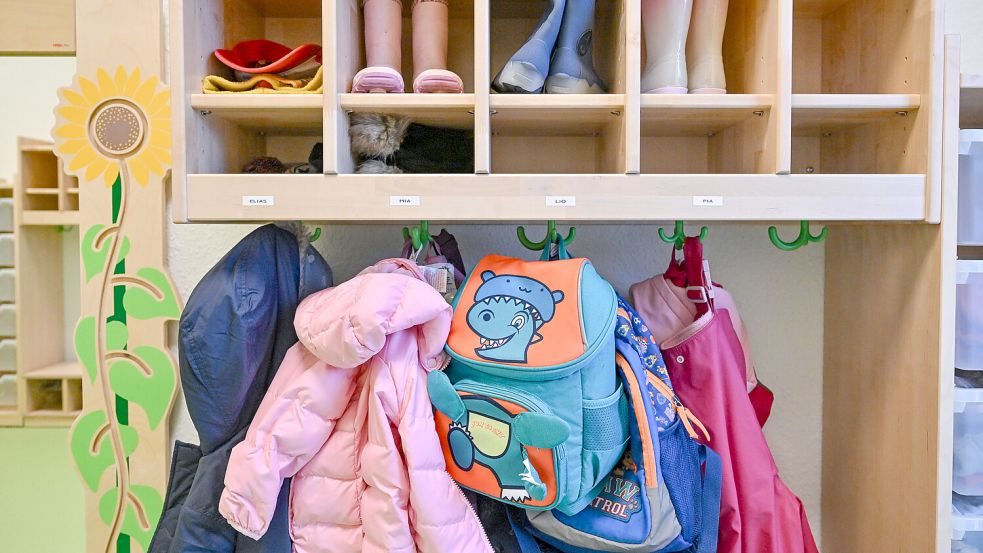 Jacken und Taschen hängen an einer Garderobe in einem Kindergarten. Foto: Patrick Pleul/DPA