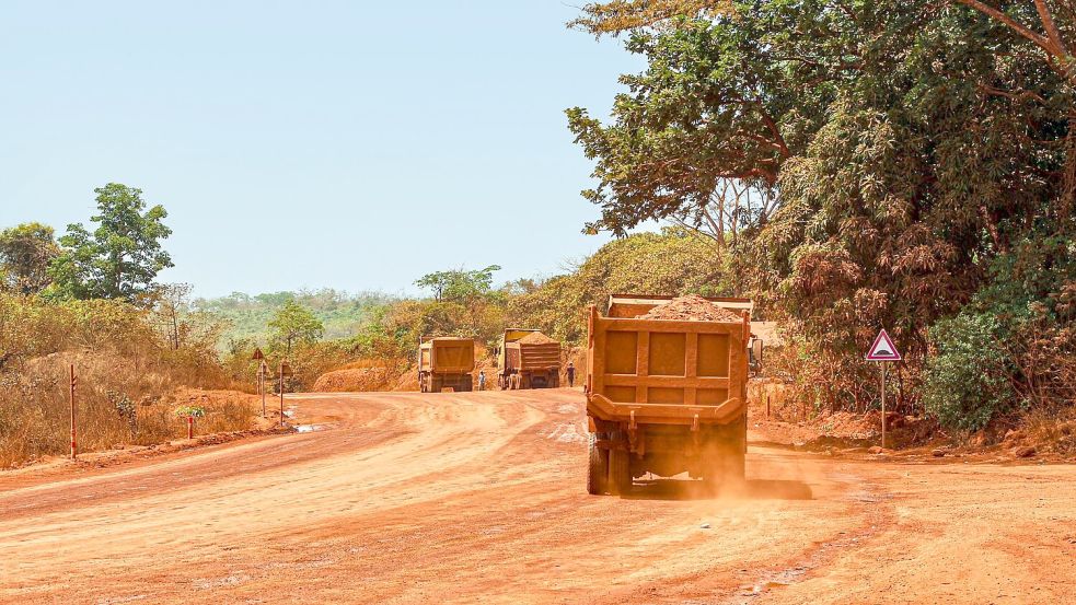 Lastwagen transportieren Bauxit entlang einer Bergbau-Transportstraße. Laut einer Studie werden mehr als ein Drittel der Menschenaffenpopulation in Afrika durch Bergbau gefährdet. Foto: Claude Frenette/iDiv/dpa