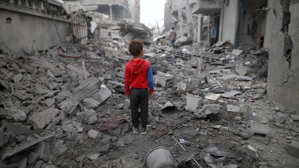 Ein Junge steht vor den Trümmern nach einem Luftangriff im Flüchtlingslager Maghazi im Zentrum des Gazastreifens. Schon sechs Monate lang tobt der Gaza-Krieg. Foto: Uncredited/XinHua/dpa