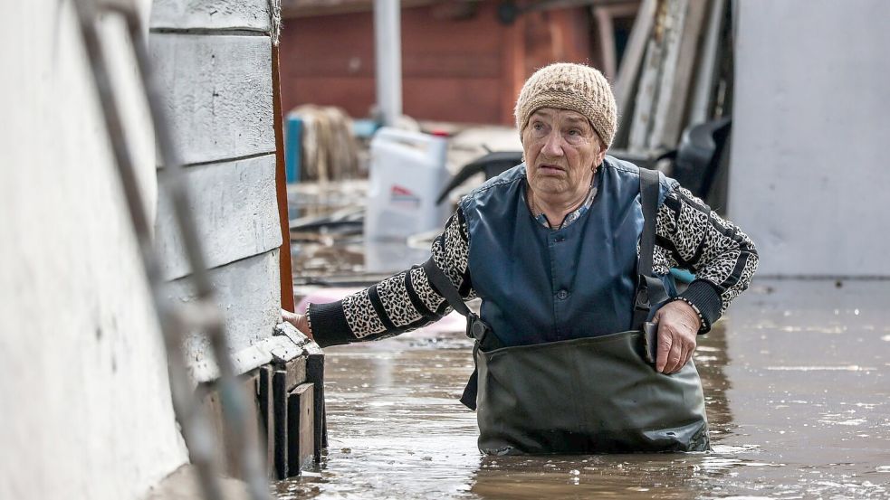 Eine Frau in der Nähe ihres Hauses in einem überschwemmten Gebiet in Orenburg, Russland. Foto: Uncredited/AP/dpa