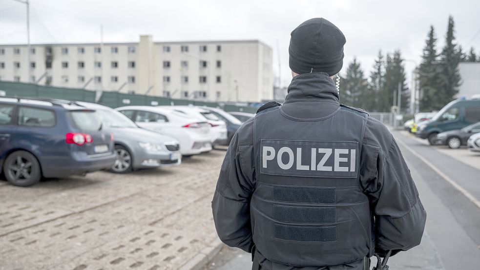 Ein Polizeibeamter läuft über einen Parkplatz. Foto: dpa