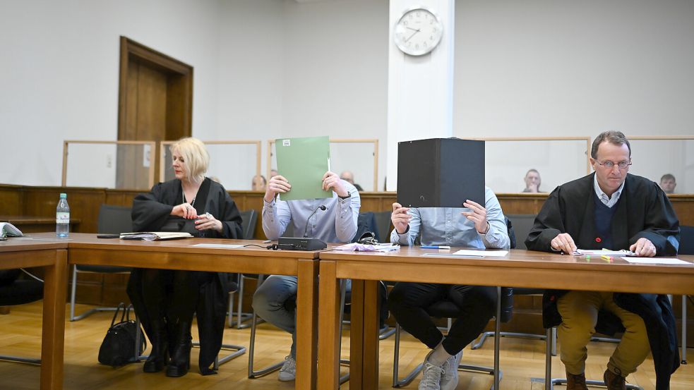 •Mit verdeckten Gesichtern sitzen die beiden Angeklagten neben ihren Verteidigern Tanja Brettschneider und Folkert Adler beim Auftakt des Prozesses in Aurich. Foto: DPA