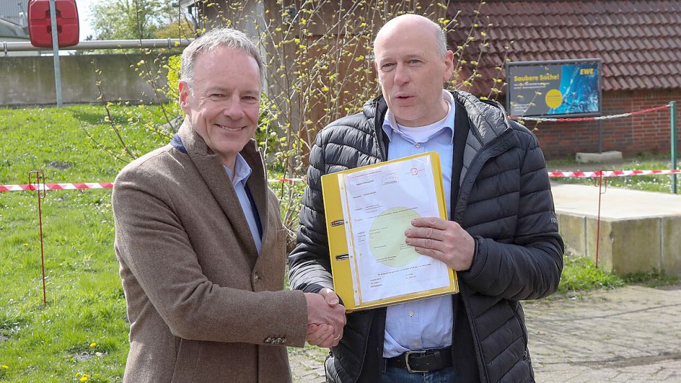 EWE Wasser-Geschäftsführer Ralph Kraemer (links) überreicht die Baugenehmigung an Bürgermeister Erwin Adams. Foto: Romuald Banik