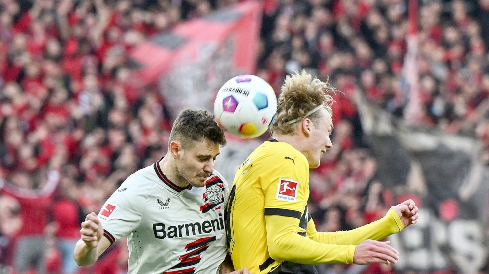 Leverkusens Josip Stanisic und Dortmunds Julian Brandt kämpfen um den Ball. Foto: Federico Gambarini/dpa