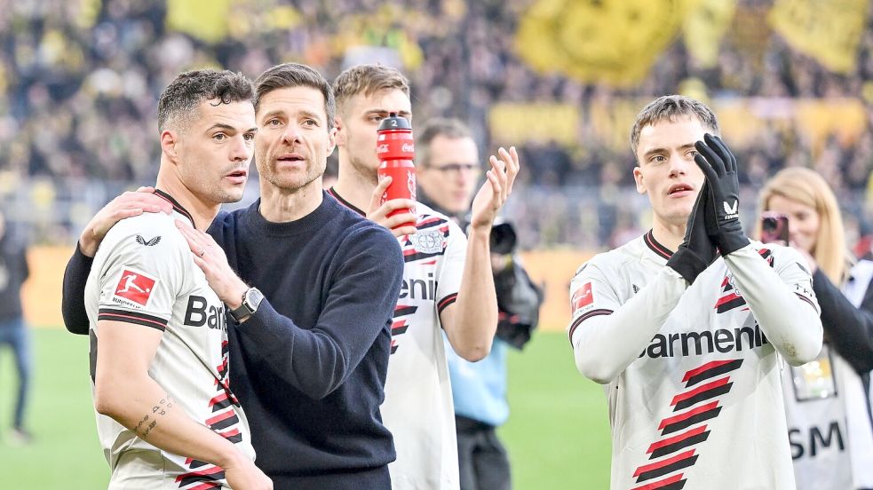 Leverkusens Trainer Xabi Alonso feiert mit seinen Spielern das Remis bei Borussia Dortmund. Foto: Bernd Thissen/dpa