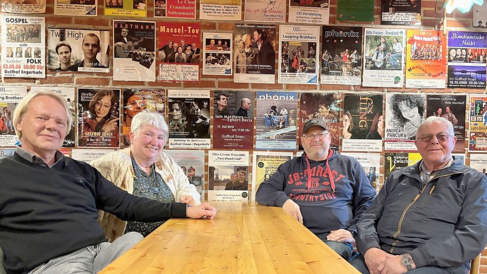 Eine ganze Wand ist mit Plakaten früherer Veranstaltungen im Gulfhof tapeziert. Jörg Lümkemann (von links), Sophia Ulferts-Dirksen, Ralf Wiese und Johannes Dirksen, die den Verein gemeinsam mit weiteren Mitgliedern führen, hoffen auf viele weitere Konzerte, Aufführungen und andere Veranstaltungen. Foto: Holger Janssen