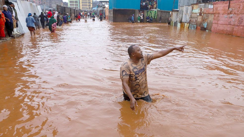 Ein Mann watet in Nairobi durch das Hochwasser. Foto: Joy Nabukewa/XinHua/dpa