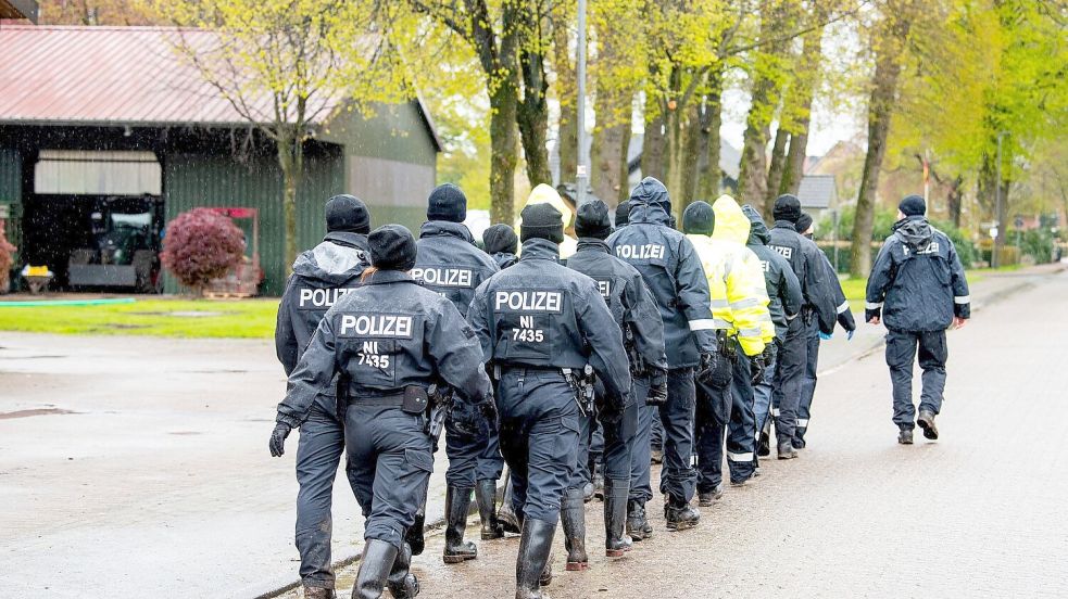 Polizisten gehen auf der Suche nach einem vermissten Jungen durch eine Ortschaft in Niedersachsen. Foto: Daniel Bockwoldt/dpa