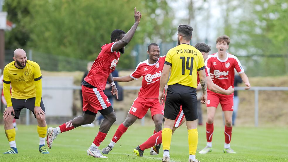 Da ist es passiert. Die Auricher (rote Trikots) haben den Führungstreffer im Derby in Middels erzielt. Bankole Jarrett (von links), Yahya Berete, verdeckt Lukas Smit und Keanu Töpfer freuen sich. Die Middelser Gyoksel Rasim (Nummer 14), und sein Mitspieler TuS-Spieler Vaja Ivaniadze (links) kann es nicht fassen. Foto: Stephan Friedrichs