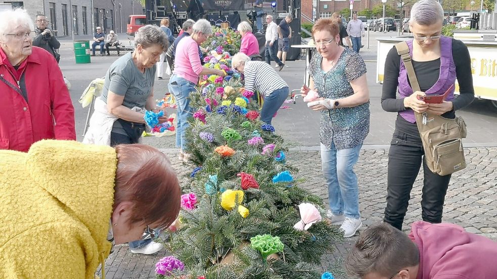 Die Frauen des Auricher Schützenvereins hatten die 500 Rosen nicht nur gemacht, sondern befestigten sie am frühen Dienstagabend auch noch fix am Baum. Foto: Karin Böhmer