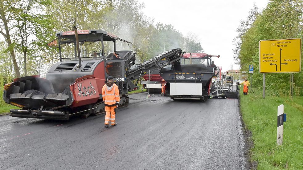 Der sogenannte Beschicker (links) füttert die beiden Fertiger mit dem 160 Grad Celsius heißen Asphalt. Foto: Thomas Dirks