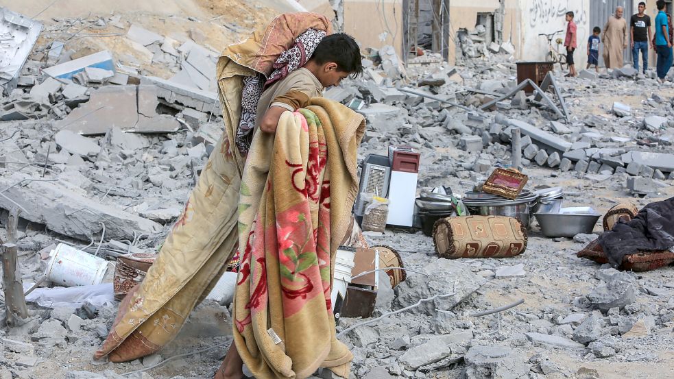 Ein Junge holt Habseligkeiten aus den Trümmern eines Hauses in Rafah. Foto: dpa/Abed Rahim Khatib