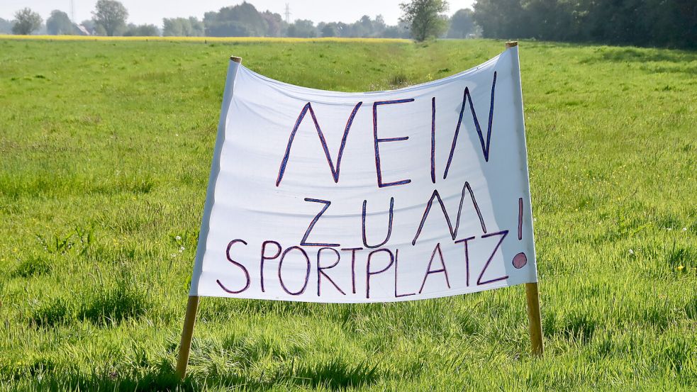 Dort, wo in Marienhafe die neue Sportstätte gebaut werden soll, stand am Sonntag dieses Protestbanner. Foto: Thomas Dirks