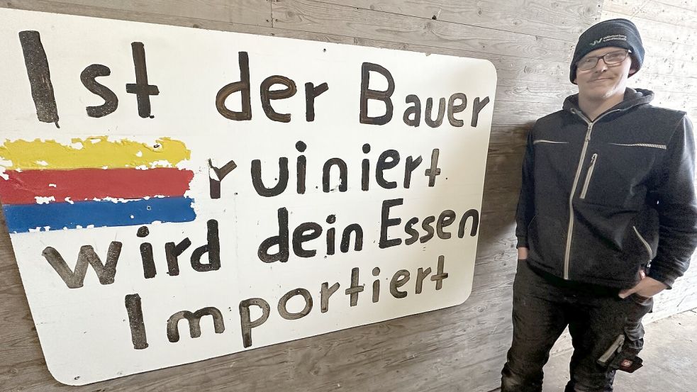 Landwirt Jann-Hendrik Arfsten von der Nordseeinsel Föhr hat das Protestplakat zur Erinnerung an die Bauerndemo in Berlin auf seinem Hof angebracht. Foto: Dirk Fisser