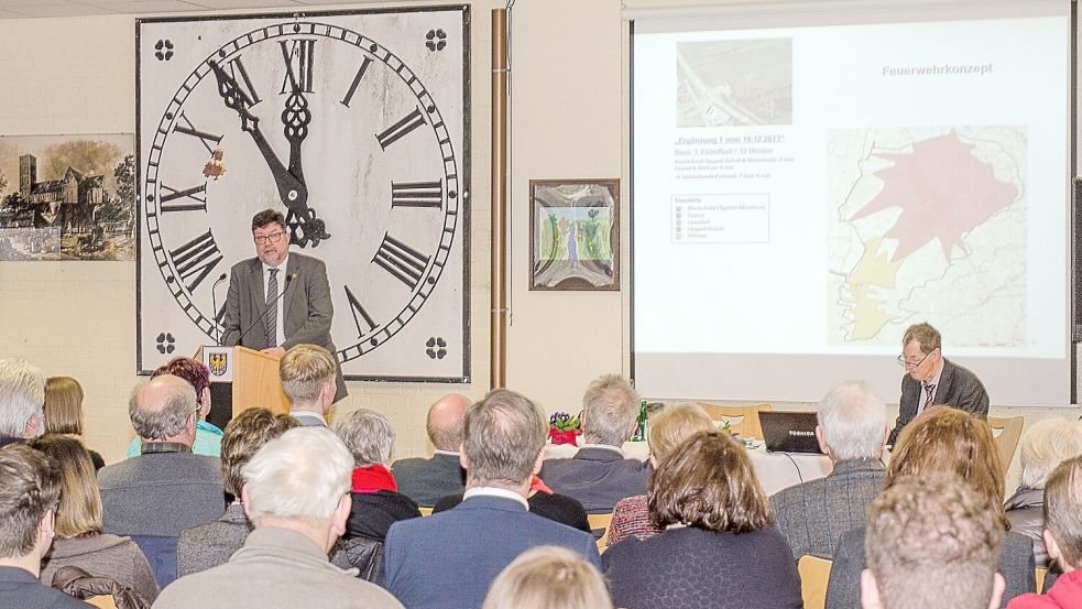 Fünf vor zwölf zeigt das alte Zifferblatt des Marienhafer Kirchturms hinter Brookmerlands Samtgemeindebürgermeister Gerhard Ihmels (SPD) in der Mensa der IGS Marienhafe beim Neujahrsempfang der Samtgemeinde 2017. Foto: Folkert Bents