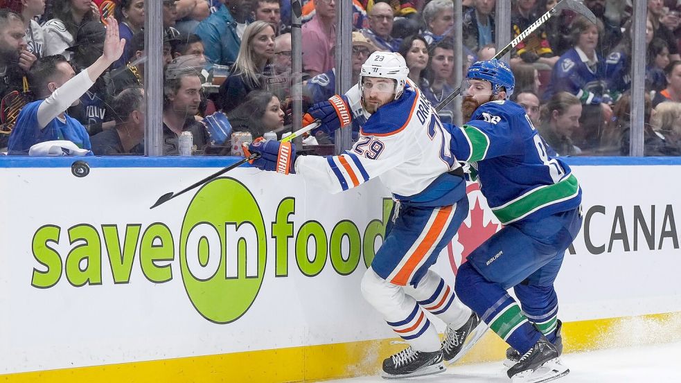 Edmontons Leon Draisaitl (l) im Zweikampf mit Ian Cole von den Vancouver Canucks. Foto: DARRYL DYCK/The Canadian Press/AP/dpa