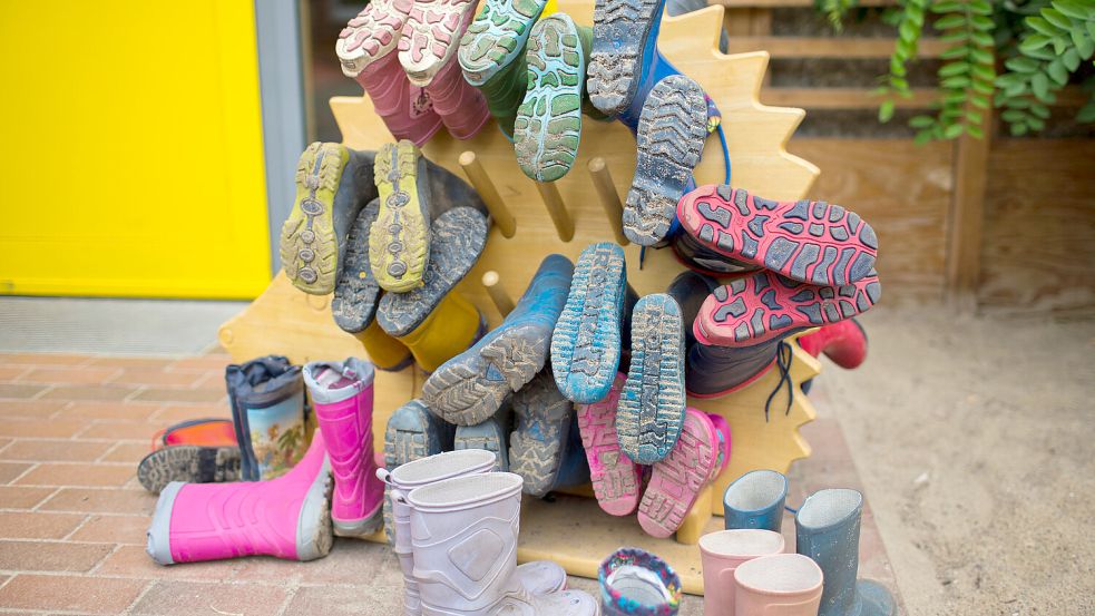 Kindergummistiefel hängen neben einem Gartenausgang in einer Kindertagesstätte. Foto: Jens Büttner/DPA