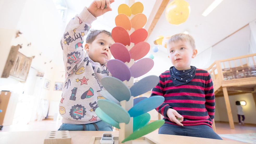 Kinder spielen in einem Kindergarten mit einer klingenden Murmelbahn. Foto: Christian Charisius/DPA