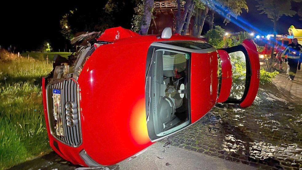 Nach dem Zusammenstoß mit der Verkehrsinsel blieb der rote Audi auf der Seite liegen: Foto: Feuerwehr, Justin Herzig