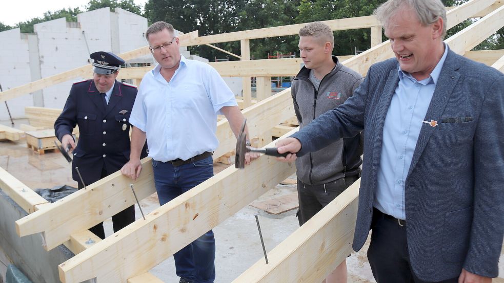 Ortsbrandmeister Manfred Gerdes (von links), Frank Süßen vom Bauamt und Bürgermeister Thomas Erdwiens (rechts) schlugen symbolisch die Nägel ein, während Polier Alexander Wilken den Richtspruch aufsagte. Zwischendurch wurde angestoßen. Foto: Karin Böhmer