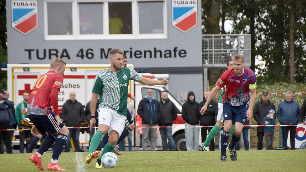 Die Turaner Björn Peters (links) und Henning Murra (rechts) nehmen den Bremer Profi Aaron Hunt in die Zange. Foto: Thomas Dirks