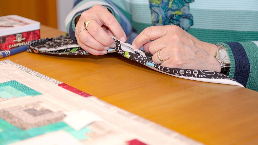 Um die Decke abzuschließen, näht die Auricherin ein Binding per Hand an. Foto: Romuald Banik