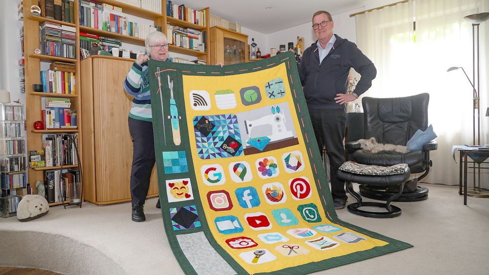 Diese große Handydecke sorgte bei der Patchwork-Gilde für Furore. Viele junge Frauen kamen in der Coronazeit mit dem modernen Thema zum Quilten. Elfriede Lübbers war ebenfalls Feuer und Flamme. Und ihr Mann Günther ist beeindruckt. Foto: Romuald Banik