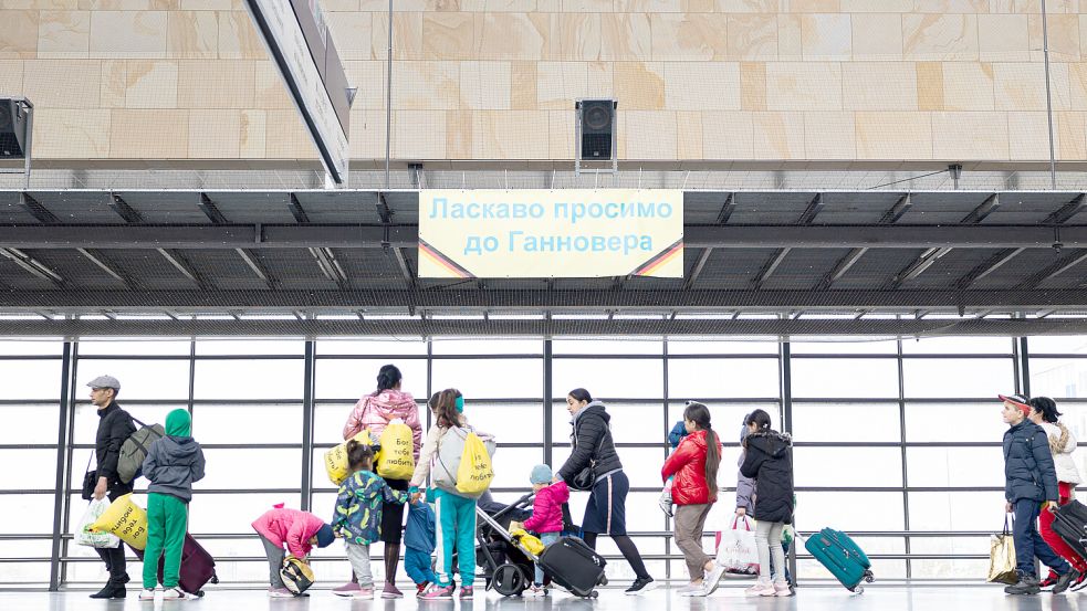 „Willkommen in Hanover“: Geflüchtete aus der Ukraine gehen durch die Eingangshalle vom Messebahnhof. Foto: dpa/Michael Matthey