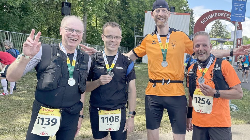 Gut gelaunt präsentierten die Auricher Ingo Frerichs (Nummer 1139) und Benjamin Hoogstraat (1108) die Finisher-Medaille für den Supermarathon. Sie trafen im Ziel auf die Ultrafriesen Markus Cramer und Thomas Brem (rechts). Fotos: privat