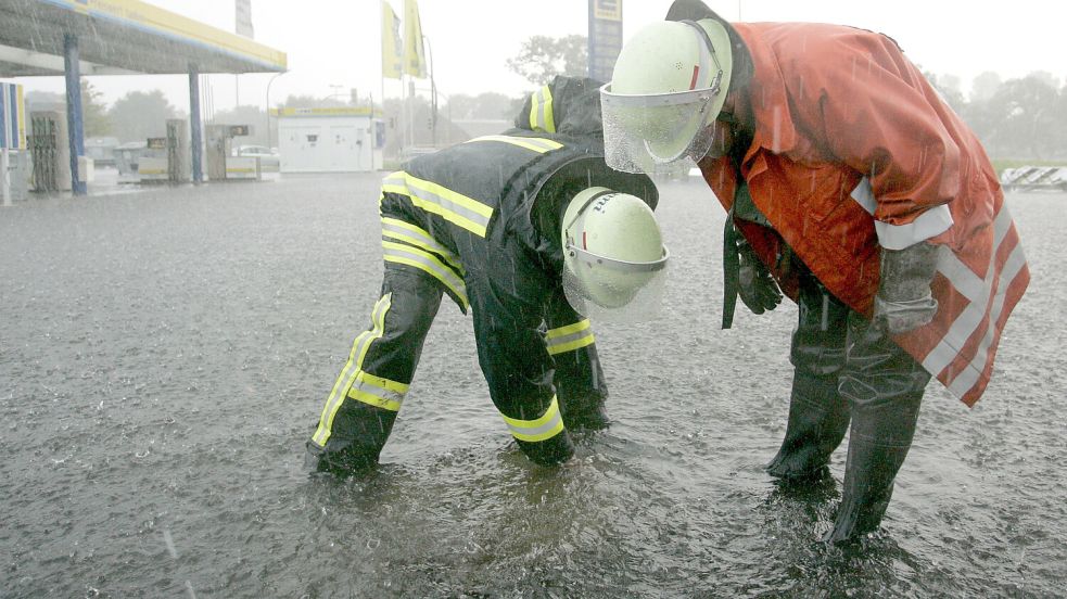 Eine Seenlandschaft war 2006 der Parkplatz bei Edeka „Parkkauf“. Die Feuerwehr musste die Gullys unter Wasser erst einmal finden. Danach wurde viel in die Entwässerung investiert. Foto: Nigel Treblin