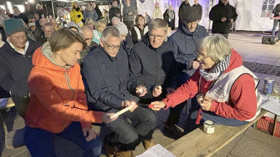 Als es dunkel wurde, wurden Kerzen angezündet. Die Omas gegen rechts kümmerten sich darum, dass es auch Landtagsabgeordnete bei Saskia Buschmann, Bürgermeister Horst Feddermann, Landrat Olaf Meinen und Pastor Axel Gärtner hell wurde. Foto: Karin Böhmer