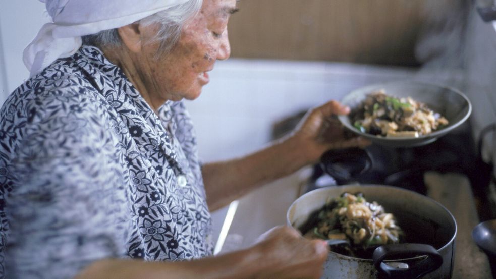Eine 97-jährige japanische Frau bereitet in Ogimi ihr Abendessen zu. Die Nahrung soll einer der Schlüssel zur Langlebigkeit in dem Ort sein, glauben seine Bewohner. Foto: Imago/Aurora Photos