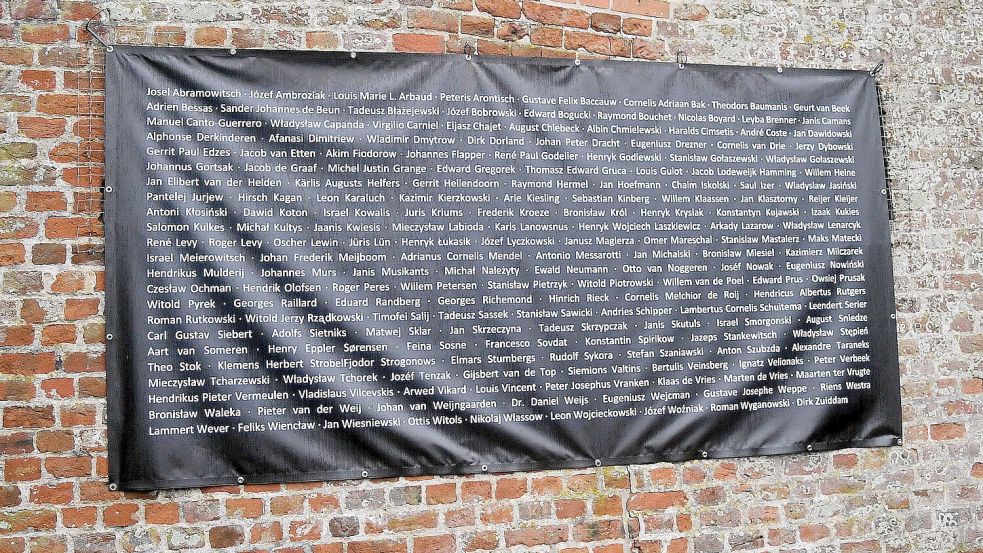An einer Mauer neben der Kirche in Enagerhafe hängt dieses Banner mit den Namen der Verstorbenen. Foto: Gerd-Arnold Ubben
