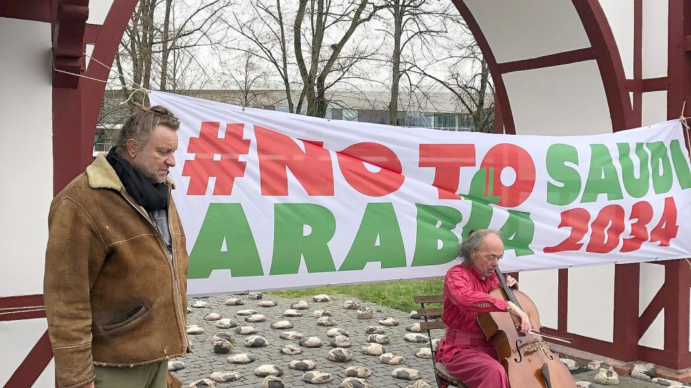 Der Osnabrücker Künstler Volker-Johannes Trieb und Melleraner Cellist Willem Schulz bei der Mahnwache gegen die WM-Vergabe nach Saudi-Arabien vor dem DFB-Campus in Frankfurt am Main. Foto: Raimer Wolter