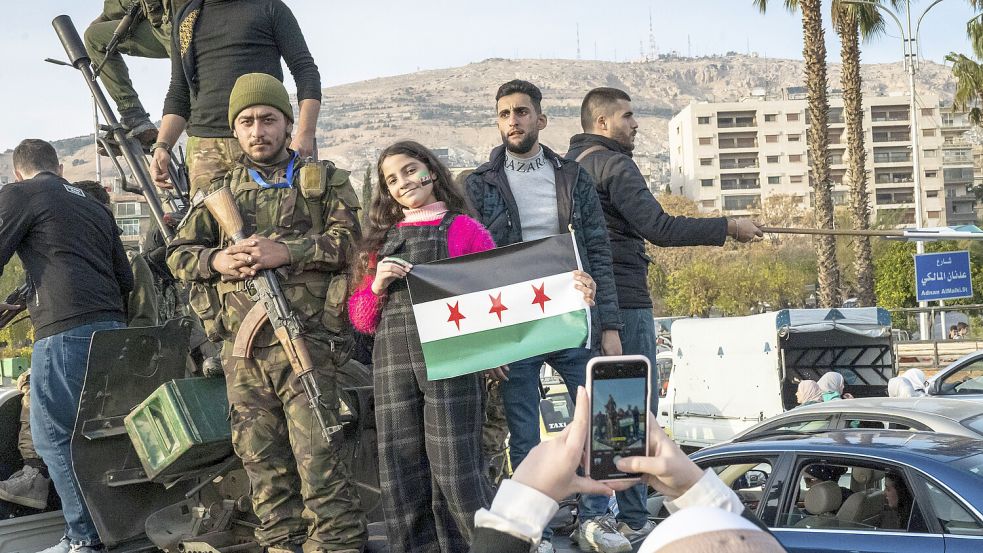 Menschen feiern den Sturz des Assad-Regimes auf den Straßen in Syrien. Foto: IMAGO/Middle East Images