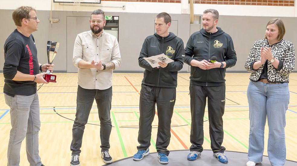 Michael Dirksen-Müller nahm stellvertretend für die Aktion für Kaufmann Ernst Moltz den Vadder-Koch-Gedächtnis-Pokal für Fairness von (von links) Eike Holzhausen (Hauptsponsor GVO), Peter Adena, Imko Swieter und Pastorin Andrea Janssen Zimmermann entgegen. Foto: Folkert Bents
