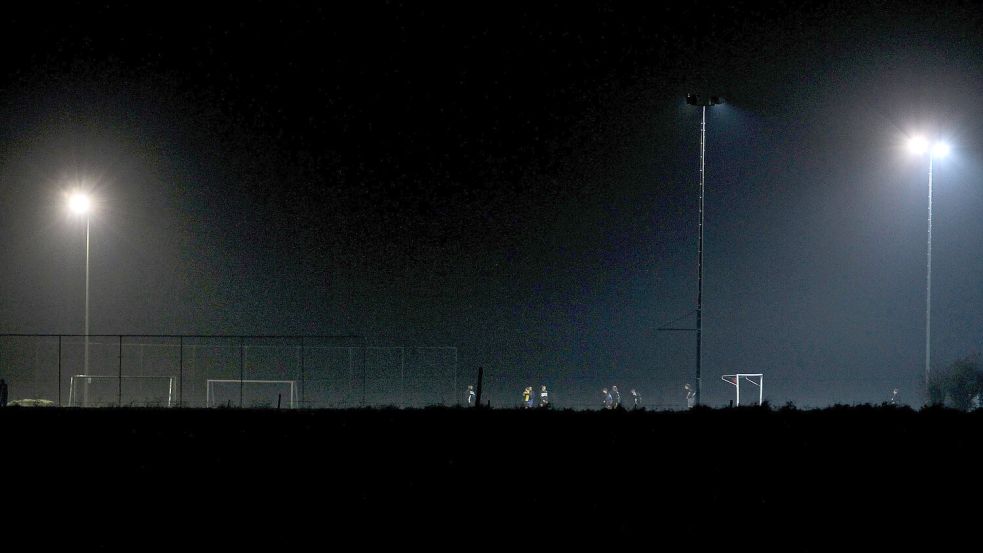 Fußballer trainieren bei Flutlicht auf einem Sportplatz. Foto: DPA