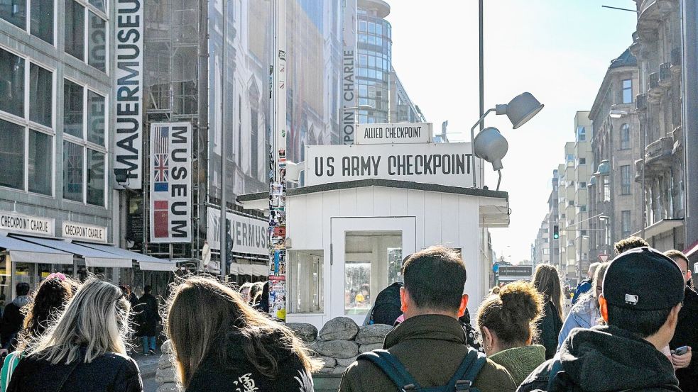 Touristen sind am Kontrollhaus am Checkpoint Charlie vor dem „Mauermuseum - Museum Haus am Checkpoint Charlie“ zu sehen. (Archivbild) Foto: Jens Kalaene/dpa